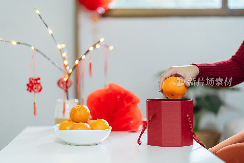 Asian Woman holding mandarin oranges with red gift box thankful present Lunar New Year. Chinese traditional holiday. Lunar new year culture.
